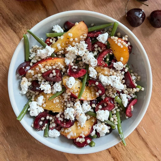 Salade de sorgho, haricots, pêches, cerises et chèvre frais
