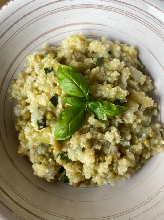Millet aux courgettes et petits pois, garni de feuilles de basilic frais.